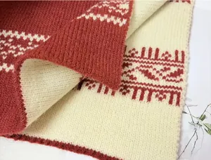 Dettaglio di sciarpa lavorata a maglia jacquard Fair Isle rosso e crema, trama morbida e fine.
