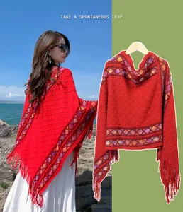 Stylish red ethnic knit poncho with colorful patterns and tassels on model and hanger