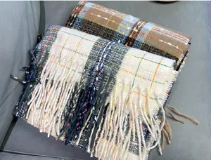 Macro view showing the soft texture of plaid imitation cashmere scarves with elegant tassels