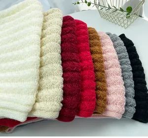 Stack of colorful knitted winter scarves showing texture variations