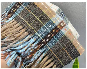 Detail of a soft plaid imitation cashmere winter scarf with multi-colored fringes