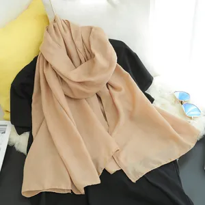 Detailed view of a lightweight khaki cotton linen scarf elegantly draped on black shirt