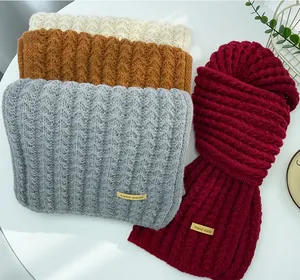 Close-up of knit winter scarves showing rich textures in red, grey, brown and cream.