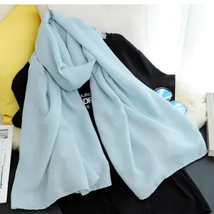 Close-up detail of a light blue solid color cotton linen scarf showing soft fabric texture.