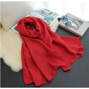 Bright red lightweight cotton linen scarf styled with fashion sunglasses and books