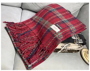 Close-up of a thick red and green plaid imitation cashmere scarf with fringe detail