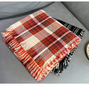 Close-up of red plaid and black houndstooth scarves with fringe detail