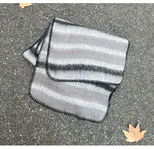 Detail view of the black blanket stitch edge on a grey gradient mohair winter scarf.