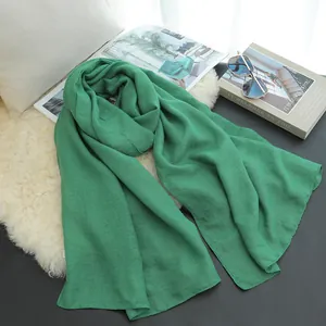 Close-up of elegant solid green cotton-linen scarf shown in a stylish lifestyle setting
