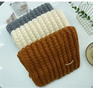 Detailed texture of folded knitted wool scarves in grey, beige, and brown colors
