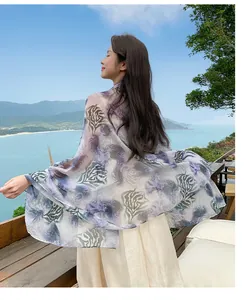 Rear view of a light purple printed beach shawl blowing in the ocean breeze at a balcony