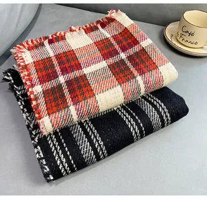 Close-up of soft winter scarves in red plaid and black houndstooth with fringe