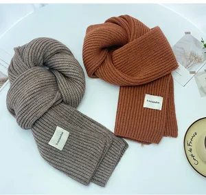 Dettaglio ravvicinato di sciarpe a maglia grossa in grigio e arancio ruggine a coste