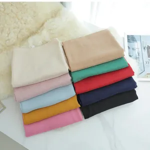 Solid color cotton linen scarves in various colors on a white marble background