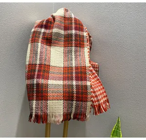Close-up of double-sided red plaid scarf with houndstooth pattern and fringe detail