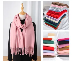 Detailed view of various solid color cashmere-like scarves with fringe edges.