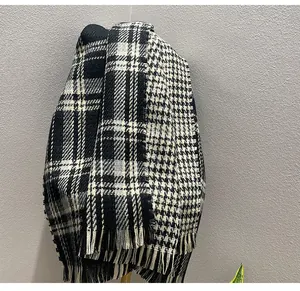 Detailed macro view of vintage black and white houndstooth plaid scarf with fringes