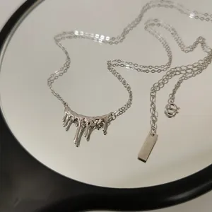 Nahaufnahme einer Halskette aus 925er Sterlingsilber mit einem lavaartigen Tropfenanhänger.