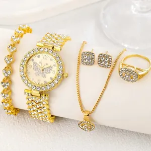 Close-up of gold-plated women's jewelry set with butterfly watch and rhinestones