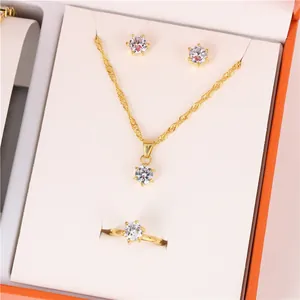 Elegant gold jewelry set featuring sparkling crystal necklace, ring, and stud earrings.