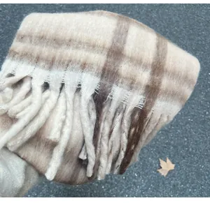 Detail view of a luxury mohair plaid scarf with thick tassels and soft winter texture