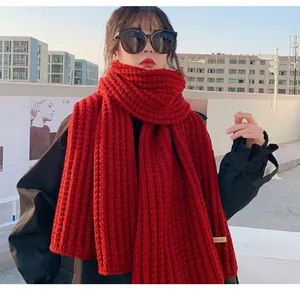Vista dettagliata di una spessa sciarpa invernale rossa lavorata a maglia su una modella