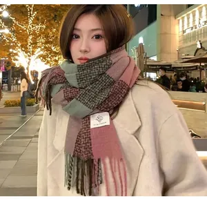 Close-up of stylish pink and green plaid mohair-style warm scarf with soft tassels.