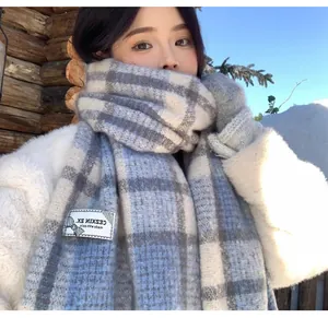 Close-up detail of a thick blue and white plaid mohair scarf for winter warmth.