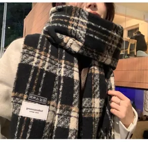 Gros plan d'une écharpe à carreaux en imitation cachemire portée dans un cadre cosy