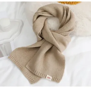 Detailopname van de zachte gebreide textuur van deze havermoutkleurige warme wintersjaal.