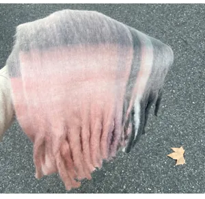 Close-up detail of soft pink and grey mohair plaid scarf with thick fringe tassels