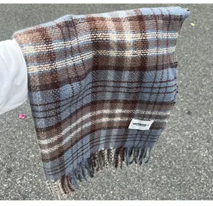 Detailed view of soft blue and brown plaid faux cashmere scarf with elegant fringe