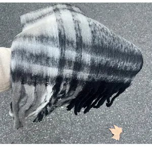 Detail of mohair plaid scarf with black and grey check pattern and tassels