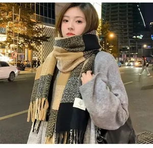 Stylish woman wearing a checkered mohair scarf with tassels in a night city street