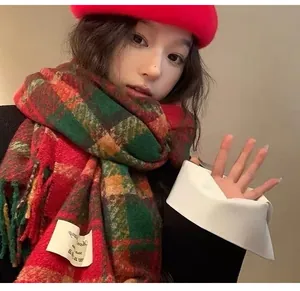 Close-up of a festive red and green plaid scarf worn by a model in a red beret.