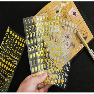Primer plano de pegatinas DIY de letras y números metálicos dorados y plateados