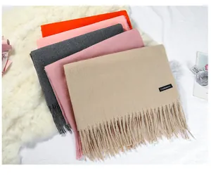 Multi-colored imitation cashmere scarves stack featuring soft tassels and a label.