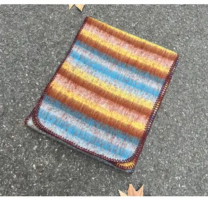 Detailed view of the fuzzy mohair texture and stitched edge of the multi-colored striped scarf.
