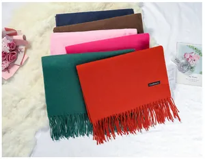 Detailed view of assorted solid color cashmere-feel scarves with soft fringe details.