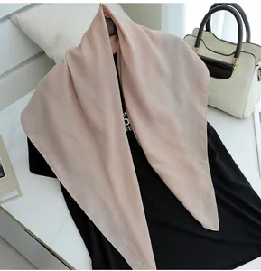Close-up detail of lightweight beige cotton linen scarf draped elegantly on a black shirt.