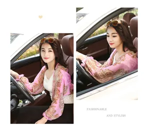 Detailed view of paisley print chiffon sun shawl worn by model while driving in car interior
