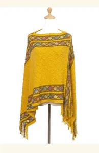 Detail of yellow ethnic style knitted poncho with colorful patterns and long tassels