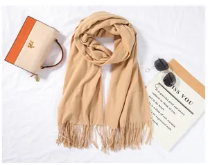 Soft camel cashmere-feel scarf with elegant fringe detail on a flat lay background.