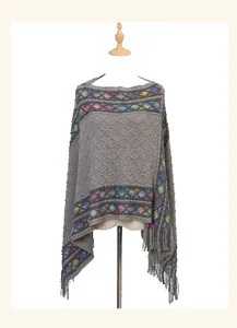 Close-up of ethnic knit poncho with colorful patterns and grey fringe detail