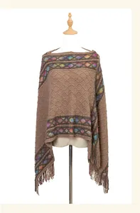 Detailed view of ethnic knit poncho featuring colorful diamond patterns and tassel fringe trim