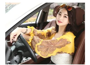 Detail shot of an Asian woman in a car wearing a yellow paisley print chiffon sun protection shawl.