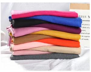Detailed stack of multi-colored solid cashmere-like scarves with soft texture