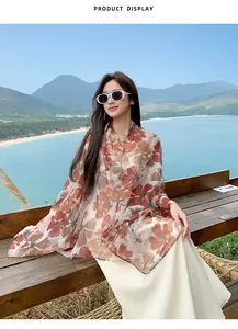 Elegantly styled Asian model wearing a long floral print sun protection scarf on a beach