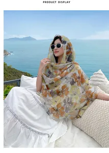 Floral print bali yarn sun protection shawl worn as a headscarf by the ocean.