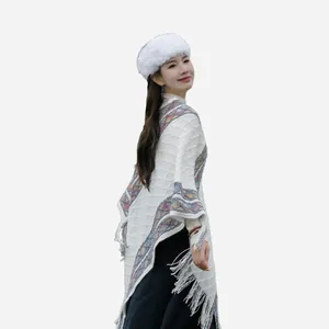 Winter ethnic style knitted white poncho for women featuring colorful patterns and tassels